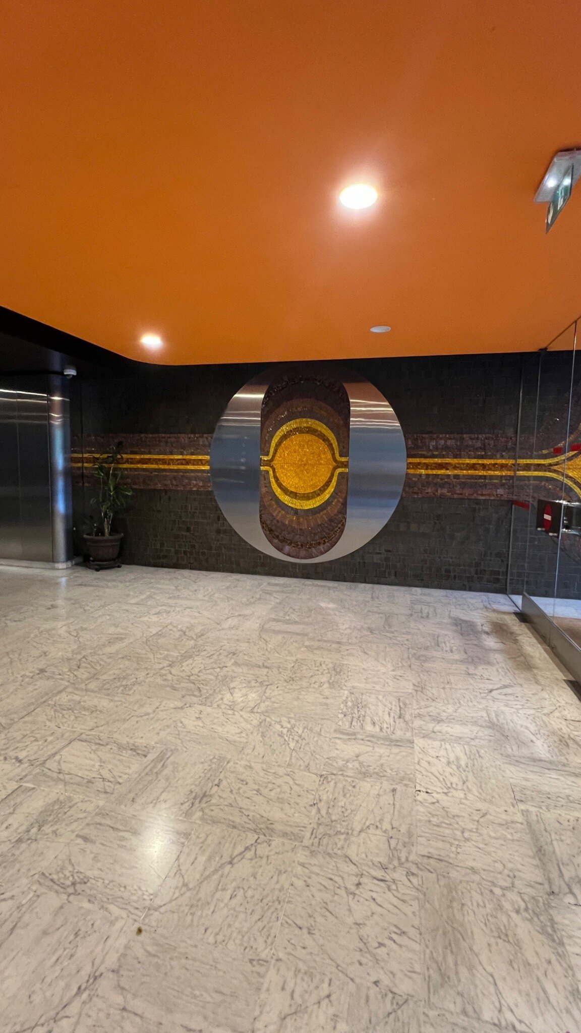 Détail du décor monumental en mosaïque et acier inoxydable dans le hall