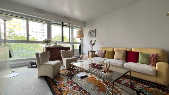 Séjour lumineux de l'appartement place Pinel avec larges fenêtres