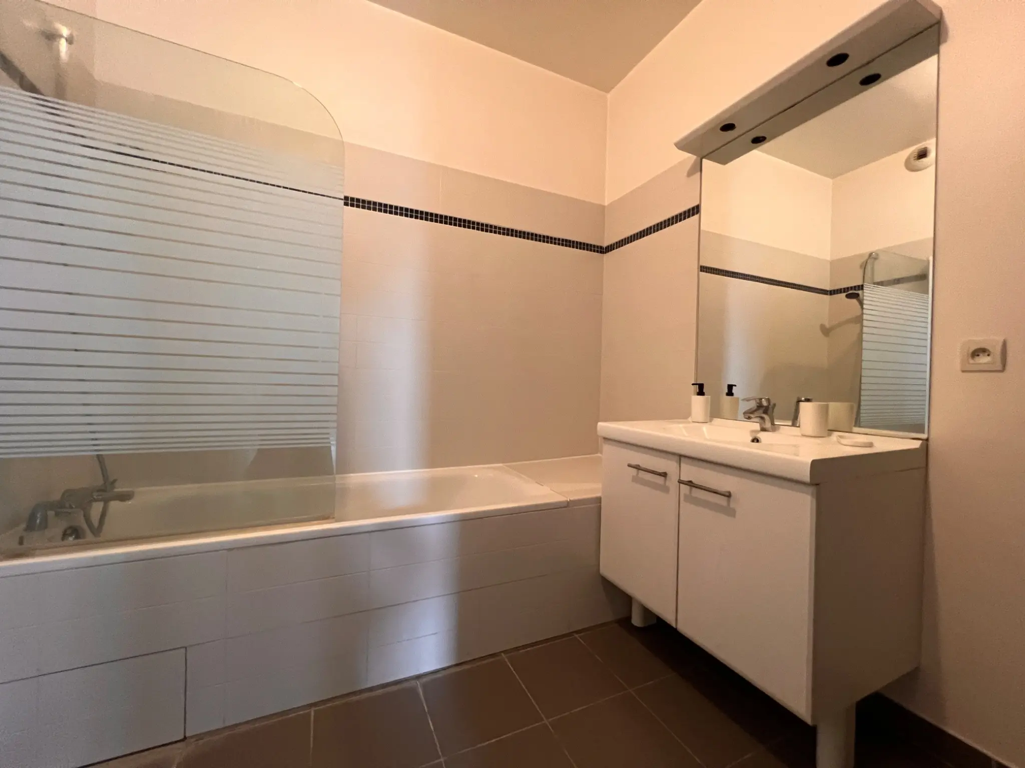 Salle de bains avec baignoire et meuble vasque
