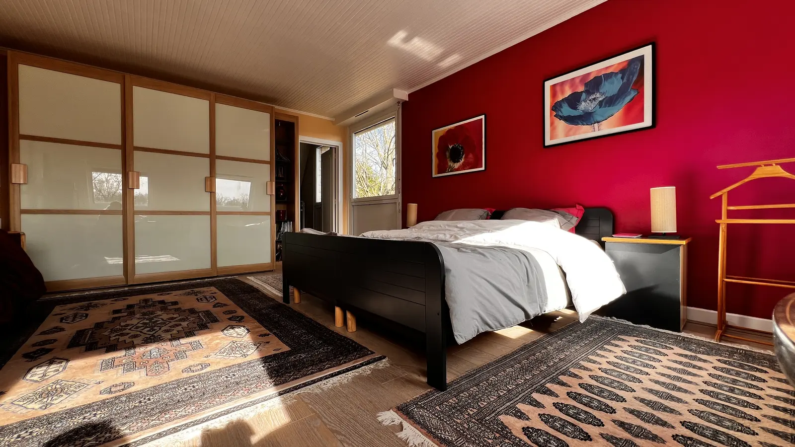Grande chambre avec rangements et mur rouge